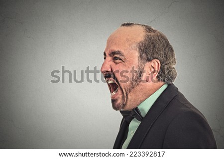 portrait of middle aged angry man screaming isolated on grey background