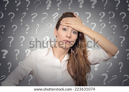 Portrait stressed woman with headache has many questions isolated grey wall background with question marks. Human emotion face expression feeling body language life perception problem solution concept