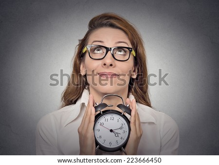 alarm-clock. headshot young excited business woman with alarm clock isolated grey wall background. Human face expressions, emotions. Time, punctuality, busy schedule concept