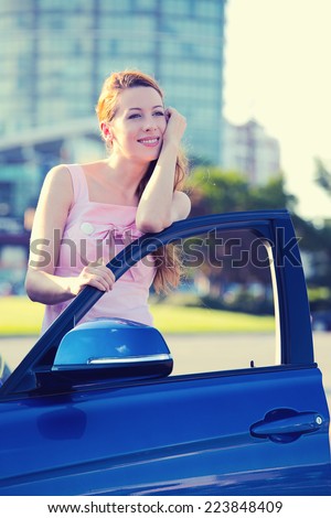 Portrait happy smiling young attractive woman buyer standing next to her new blue car  isolated outside dealer dealership lot corporate office background. Personal transportation auto purchase concept