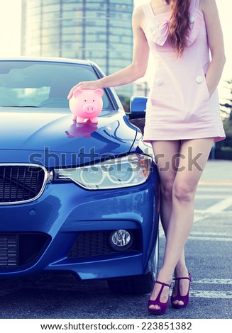 Cropped image woman customer, agent standing next to new car, piggy bank on hood isolated outside outdoor. Dealership offering credit line finance services. Lease automobile purchase financing concept