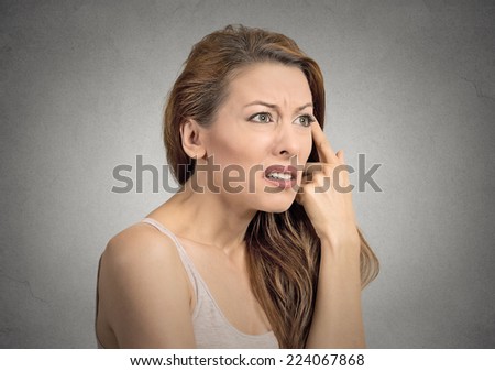 Closeup portrait angry mad young woman gesturing with her finger against temple asking are you crazy isolated grey wall background. Negative human emotion facial expression feeling body language