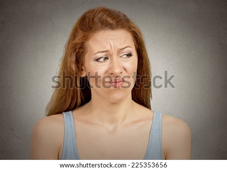 Upset disgusted woman with displeased face expression isolated on grey wall background. Human emotion feeling body language life perception attitude
