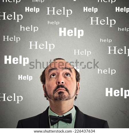 Closeup headshot man looking up for help isolated on grey wall background