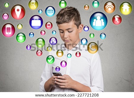 Handsome teenager boy using smartphone pad computer playing game social media icons flying from screen isolated grey background. New generation technology concept. Modern gadgets information source