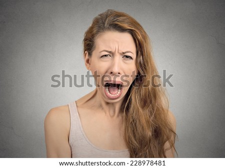 Portrait angry upset woman screaming crying wide open mouth hysterical face grimace isolated grey wall background.Negative human expression emotion bad feeling reaction. Conflict confrontation concept