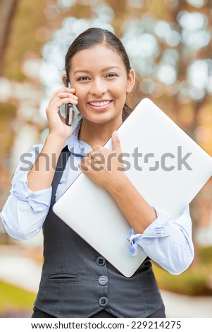 Portrait young woman, attractive businesswoman talking on cell phone having pleasant conversation receiving good news walking in park isolated outdoors autumn tree background. Positive face expression