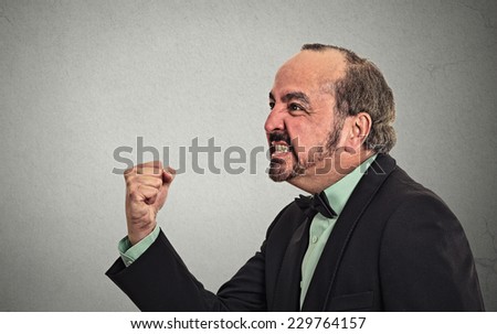 Side profile portrait angry middle aged man isolated on grey wall background