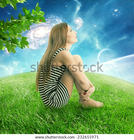 Thoughtful young woman sitting on on a green meadow earth planet looking up at starry sky with moonlight. Ecology eco friendly world concept. Dreamland outdoors relaxation environment  screen saver