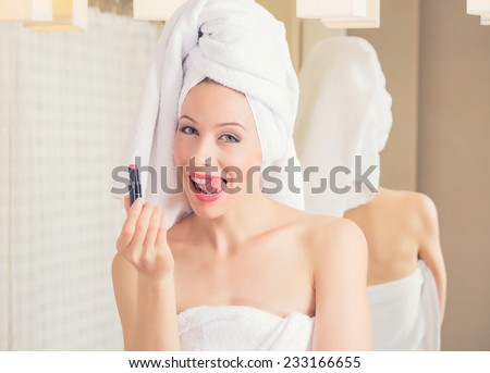 Portrait young woman in hotel bathroom smiling with towel on her head after bath refreshing herself applying makeup. Positive face expression emotion feeling. Healthy life wellness happiness concept