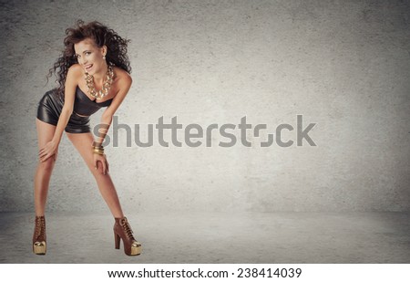 Full Length Portrait of beautiful Young Woman in Short Black Fashion Dress standing isolated on grey wall background with copy space. Positive face expression, emotion. Beauty fashion concept