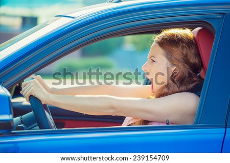 Closeup side window view displeased angry pissed off aggressive woman driving car shouting screaming at someone isolated traffic background. Emotional intelligence concept. Negative human emotion