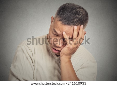 Closeup portrait headshot sad bothered stressed middle aged man holding head with hand really depressed about something isolated grey wall background. Negative human emotion facial expression feeling