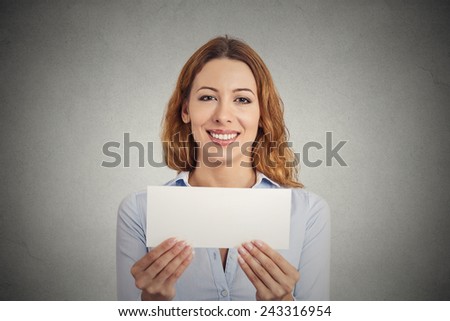 Gift card. Excited woman showing empty blank paper card sign with copy space for text. Gorgeous female model isolated on grey wall background. Positive face expressions emotions feelings