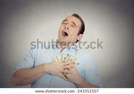 Closeup portrait happy excited successful business man in love with money, funny looking guy holding dollar bills in hand isolated grey wall background. Human emotions, facial expressions, feeling