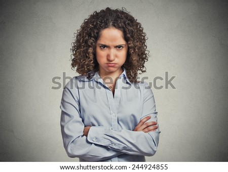 Closeup portrait of angry young woman puffing cheeks isolated on grey wall background. Negative human emotions face expressions feelings perception