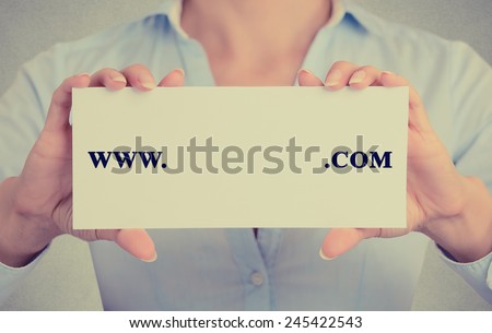 Closeup retro vintage style image business woman hands holding white sign card with www. com written on it with empty space ready for your text website domain isolated on gray office wall background