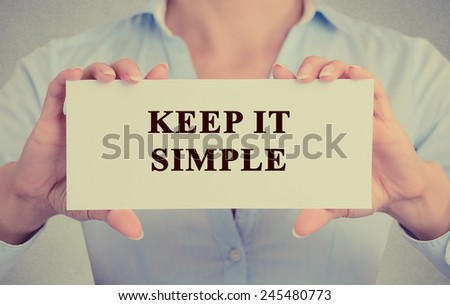 Retro instagram style image businesswoman hands holding white card sign with keep it simple message text isolated on grey wall office background