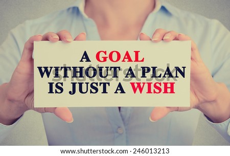 Closeup businesswoman hands holding white card sign with a goal without a plan is just a wish text message isolated on grey wall office background. Retro instagram style image