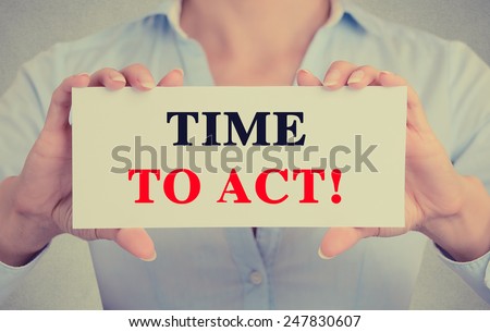 Businesswoman hands holding white card sign with time to act text message isolated on grey wall office background. Retro instagram style image