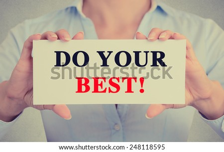 Businesswoman hands holding white card sign with do your best text message isolated on grey wall office background. Retro instagram style image