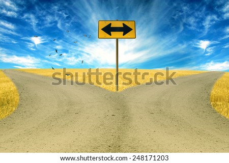 two roads, road sign ahead with arrows blue sky background. Countryside landscape