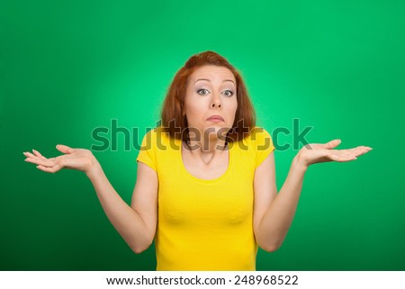Closeup portrait puzzled clueless young woman with arms out asking what is problem who cares so what I don\'t know isolated green background. Negative human emotion face expression reaction perception