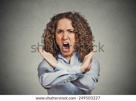 Angry screaming young woman making showing stop gesture isolated on grey wall background Negative human emotion facial expression feelings, sign symbol body language, reaction nonverbal communication
