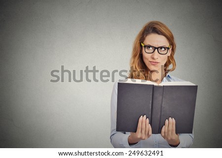 Closeup clever woman reading book having thought isolated on grey wall background. Human face expression