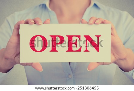 Closeup businesswoman hands holding white card sign with open text message isolated on grey wall office background. Retro instagram style image