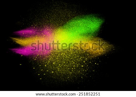 Freeze motion of colorful powder exploding isolated on black dark background. Abstract design of color dust cloud. Particles explosion screen saver, wallpaper.
