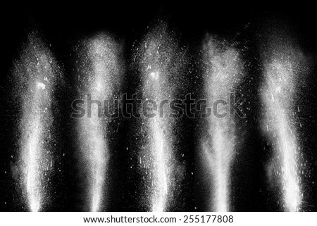 Freeze motion of white powder paint exploding streaming up isolated on black dark background. Abstract design of dust cloud. Particles explosion screen saver, wallpaper brush