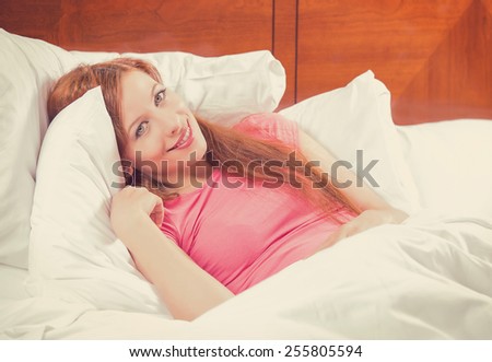 beautiful young woman waking up in bed at home