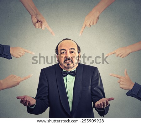 Concept of accusation of guilty arrogant businessman. Middle aged man judged by different people many women fingers point at him. Guy shrugs shoulders