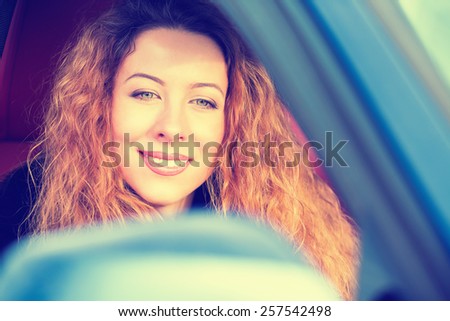Portrait happy young woman driving on road trip on beautiful sunny winter day. Positive face expression emotion