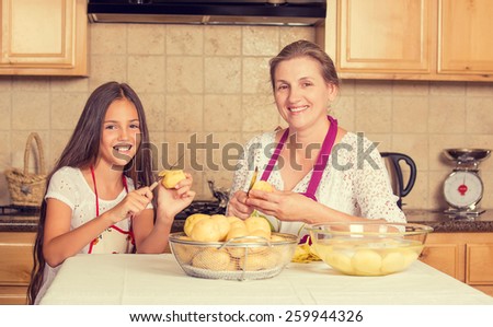 Portrait of happy, smiling mother and daughter cooking dinner, preparing food isolated background home kitchen. Positive family emotions, face expression, life perception. Healthy eating concept