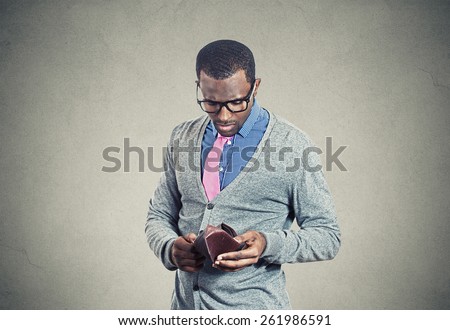 Young man looking into his empty wallet has no money
