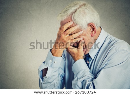 Closeup portrait sad depressed, stressed, thoughtful, senior, old man, gloomy, worried, covering his face isolated gray wall background. Human face expressions, emotion, feelings, reaction, attitude