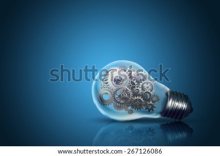 Close up of light bulb with gear mechanism inside isolated on dark blue background