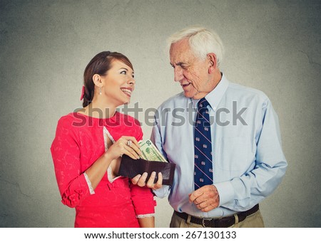 Senior elderly businessman boss and his beautiful young mistress isolated on gray wall background