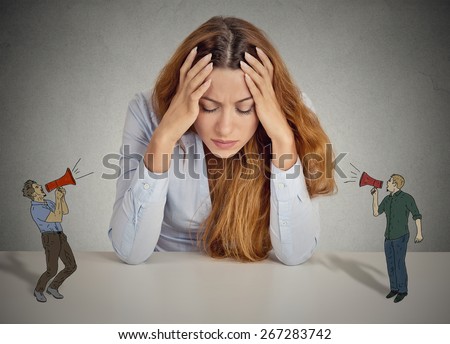 Desperate unhappy young business woman leaning on a desk two men with megaphone screaming at her isolated grey wall office background. negative human emotions face expression feelings life perception