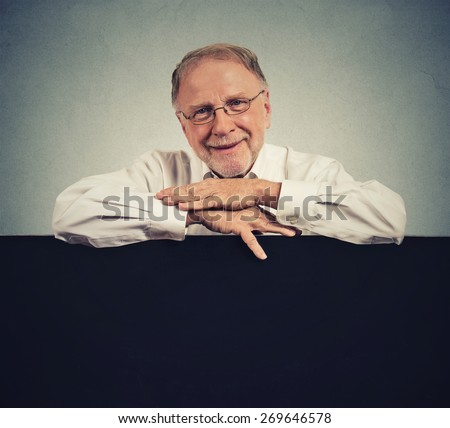 Senior happy man with blank space black banner isolated on gray wall background
