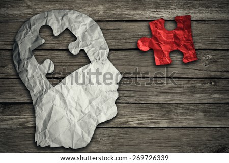 Puzzle head brain concept as a human face profile made from crumpled white paper with a jigsaw piece cut out on a rustic old wood background as a mental health symbol.