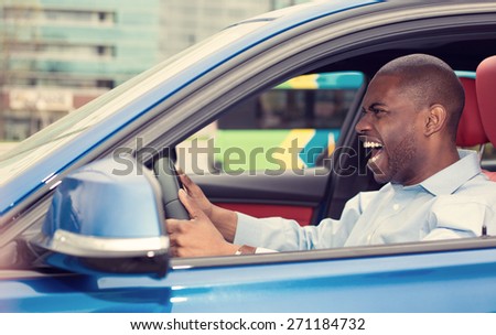 Closeup portrait displeased angry pissed off aggressive young man driving car shouting at someone isolated traffic background. Emotional intelligence concept. Negative human face expression