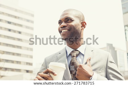 Portrait corporate man drinking coffee in sun standing outdoor in sunshine light enjoying his morning coffee. Smiling happy businessman model in his 20s. Positive face expression, emotions, feelings