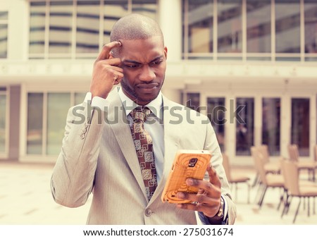 Closeup portrait upset sad skeptical unhappy serious man talking texting on phone displeased with conversation isolated outside city background. Negative human emotion face expression feeling