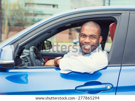 Closeup portrait happy smiling young man buyer sitting in his new car excited ready for trip isolated outside dealer dealership lot office. Personal transportation auto purchase concept