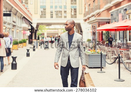 Happy man with shopping bags walking on a street