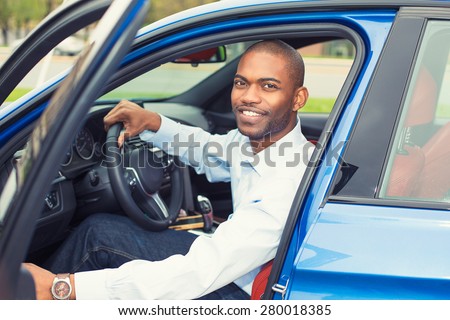 Happy handsome man in his new blue car