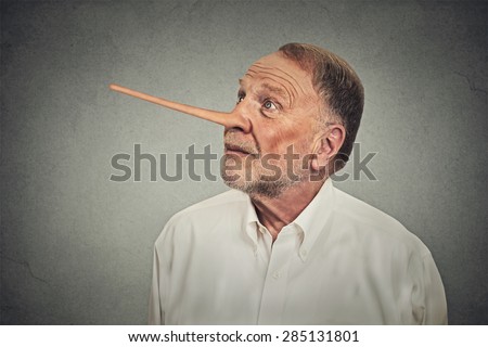 Man with long nose looking up avoiding eye contact isolated on grey wall background. Liar concept. Human face expressions, emotions, feelings.